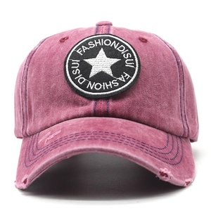 Macro shot of distressed brim and star embroidery on vintage washed burgundy baseball cap