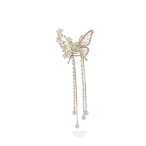 Elegant gold butterfly hair claw clip with white flower petals and long pearl tassels