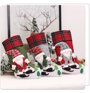 Close-up of three Christmas stockings with 3D gnomes skiing on white faux fur background
