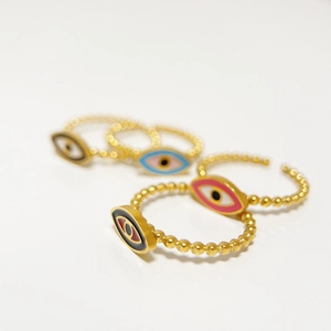 Macro detail of colorful enamel evil eye rings with a gold beaded band structure