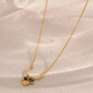 Close-up of a gold 18K plated stainless steel necklace with heart charm and green beads