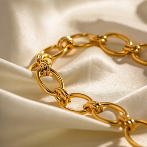 Dettaglio della catena a maglie in acciaio inossidabile placcato oro 18K su seta