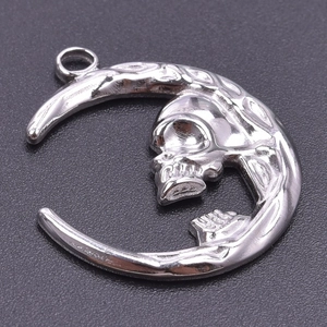 Detailed macro view of silver moon and skull pendant accessory with metallic luster