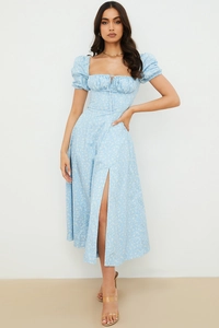 Detail view of light blue puff sleeve floral midi dress with a high side slit and tied bust