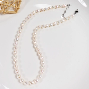 Detailed view of freshwater rice pearls with silver lobster clasp and heart charm tag