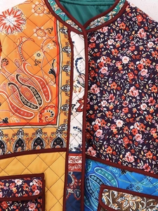 Close-up of quilted patchwork jacket with paisley patterns and floral stitch detail