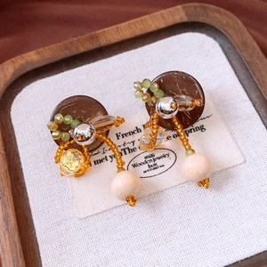 Details von handgefertigten Vintage-Ohrringen mit Holzperlen und Bernsteinkristall