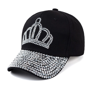 Close-up of sparkling silver rhinestones forming a crown pattern on a black baseball cap