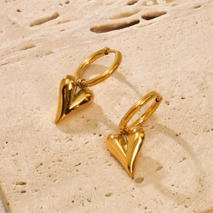 Minimalist gold stainless steel heart hoop earrings on a textured stone surface