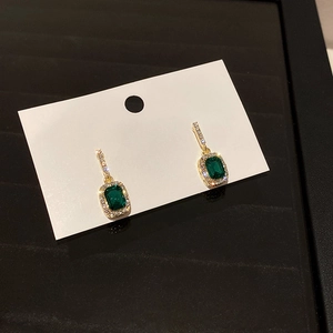 Detail of square emerald green crystal earrings with gold plating and paved micro diamonds