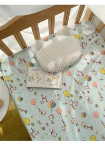 Detail of light blue muslin bamboo cotton crib sheet with cute cartoon mouse print
