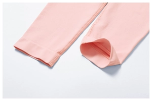 Detailed close-up of baby pink yoga pants showing neat stitching and ribbed knit texture