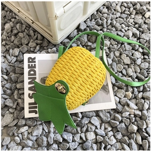 Macro detail of hand-woven pineapple bucket bag with green leaf flap and metal clasp