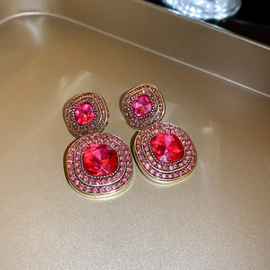 Detail of red square earrings with gold plating and sparkling crystal accents