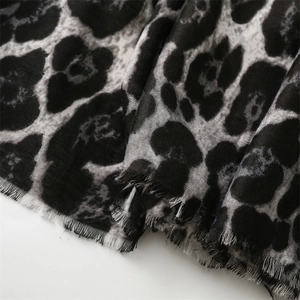 Detail of leopard print cotton-linen scarf with fringed edges and soft fabric texture