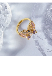 Macro detail of golden butterfly ring with pink and purple crystals and open band