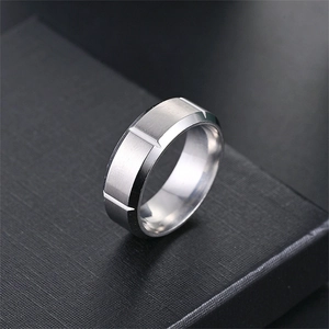 Nahaufnahme eines silbernen Herrenrings aus Titanstahl mit mattem Finish und V-Rillen.