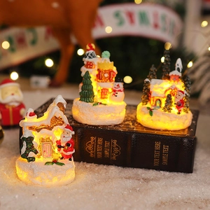 Three miniature light-up resin Christmas houses with Santa Claus and snowman details