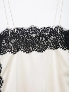 Detail of elegant black eyelash lace trim on smooth cream silk satin camisole top