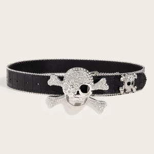 Detail of crocodile textured leather belt with silver rhinestone skull buckle and bead trim