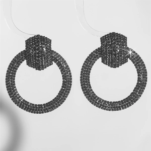 Detailed view of large black crystal hoop earrings with hexagonal studs and rhinestones