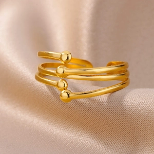 Detailed macro view of an 18k gold-plated multi-layer spiral ring on champagne silk fabric