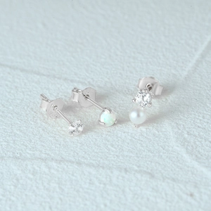 Macro detail of S925 silver stud earrings set featuring opal, pearl and zircon accents