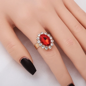 Elegant gold ring with large oval red gemstone and clear diamonds worn by model