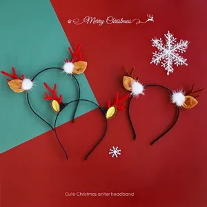 Christmas reindeer antler headband with white pom-poms on a festive background