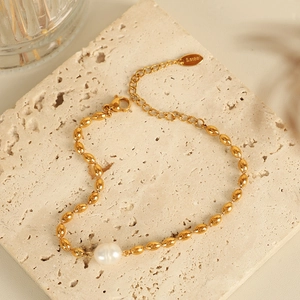 Elegant gold titanium steel necklace featuring olive beads and a unique baroque pearl