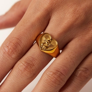 Vintage gold heart signet ring featuring an angel relief with a polished metallic finish