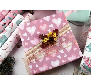 Close-up of minimalist heart pattern gift wrapping paper with rustic jute twine and dried flowers