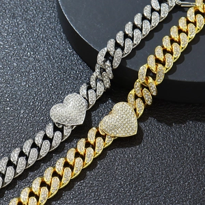 Dettaglio macro delle catene cubane oro e argento con chiusure a cuore in strass