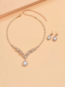 Detailed view of bridal jewelry set with gold-tone water drop necklace and teardrop earrings