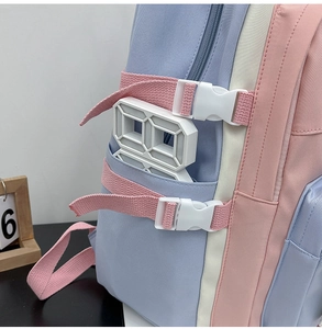 Side view detail of a blue, pink, and white color-block backpack with nylon mesh pocket