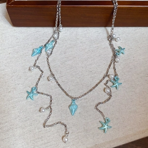 Détails du collier argenté avec pendentifs étoile de mer bleue et perles blanches