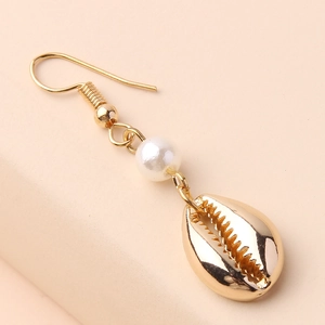 Elegant gold shell drop earrings with a white pearl on a clean peach background