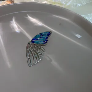 Detail of butterfly brooch with blue enamel wings and silver hollow metal skeleton