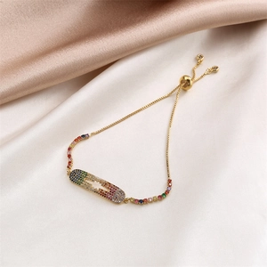 Detail of adjustable gold bracelet with colorful pavé cubic zirconia on satin fabric