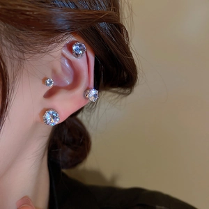 Macro detail of magnetic zircon ear clips set in silver finish on a female model
