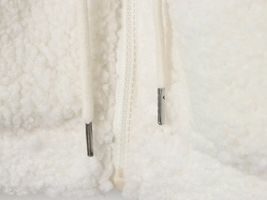 Close-up of white fleece texture with a high-neck zipper and silver-tipped drawstrings