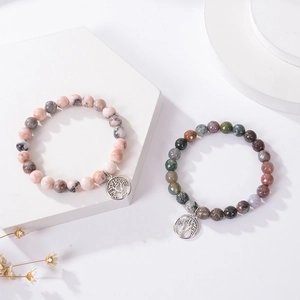 Detailed macro of natural stone beads and silver tree of life charm on the bracelet
