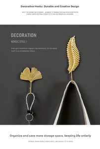 Detail of matte gold metal leaf and feather wall hooks in Nordic minimalist style
