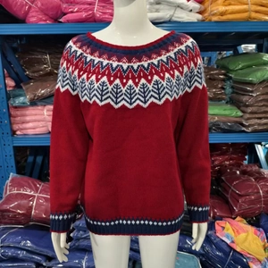 Detail van Noors Fair Isle-breipatroon op rode losvallende trui met ronde hals