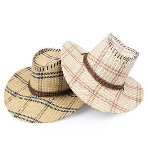 Dettaglio di due cappelli da cowboy in paglia intrecciata a quadri con corde decorative