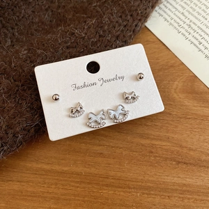Détail de boucles d'oreilles cheval à bascule serties de zircons sur carte