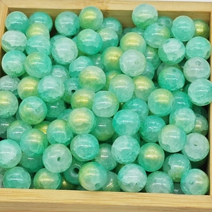 Close-up of mint green ice-crack glass beads with gold foil for DIY jewelry making