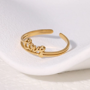Minimalist gold LOVE lettering stainless steel open ring shown on white display