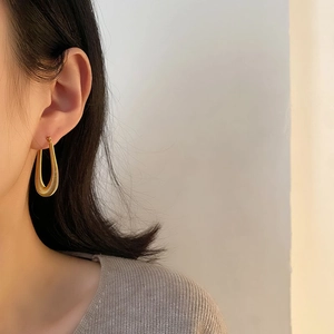 Elegant gold stainless steel U-shaped drop earrings shown on a model for a stylish look