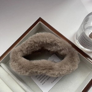 Close-up of plush coffee-toned cloud hair claw clip inside a wooden jewelry box